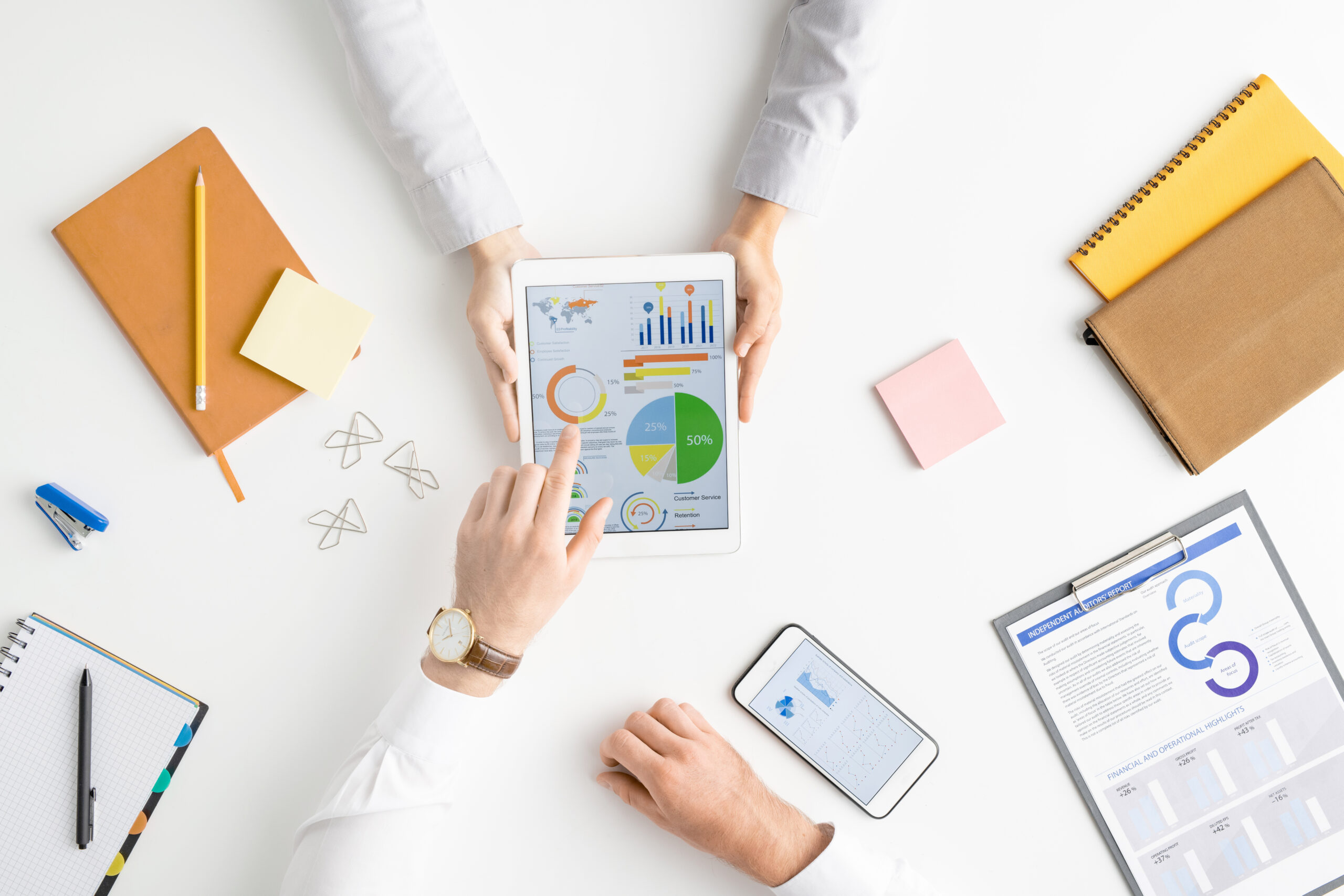 View of hands of two contemporary analysts or brokers discussing financial data View of hands of two contemporary analysts or brokers discussing financial data on touchscreen while one of them pointing at circle diagram