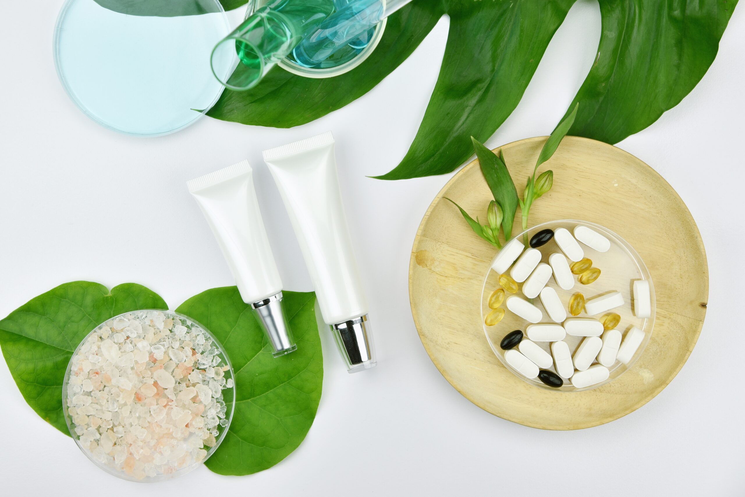Cosmetic bottle containers with green herbal leaves, Blank label Cosmetic bottle containers with green herbal leaves, Blank label for branding mock-up, Natural beauty product concept.